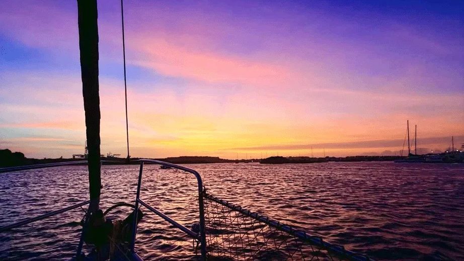 Croisière au coucher du soleil à Curaçao : la proue du bateau et le ciel embrasé sur le lagon de Spanish Water